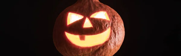 Plano panorámico de la aterradora linterna de Halloween tallada de calabaza aislada en negro - foto de stock