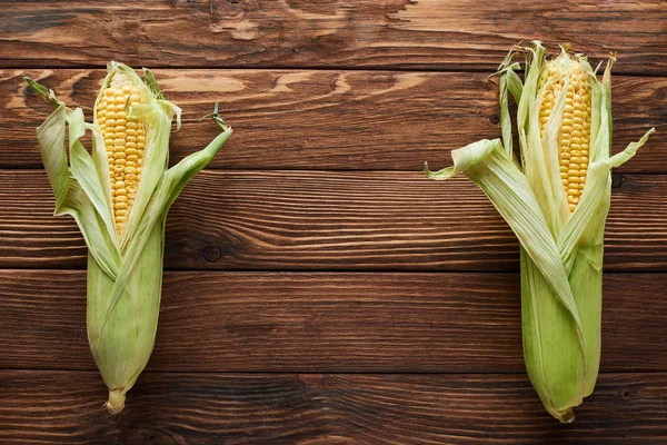 Top view of fresh corn on wooden surface with copy space — Stock Photo