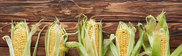 Panoramic shot of corn on wooden surface — Stock Photo