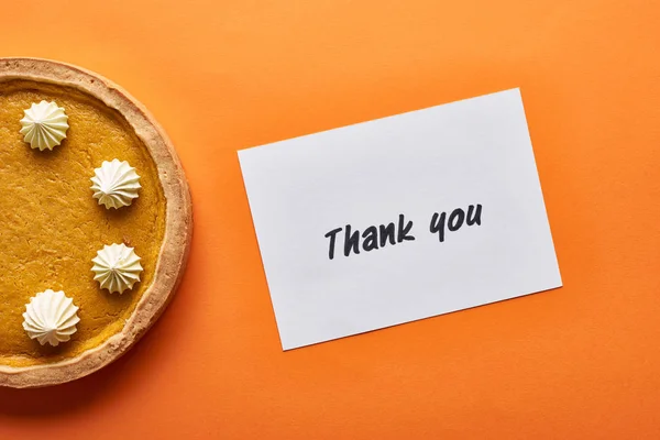 Top view of pumpkin pie and thank you card on orange background — Stock Photo