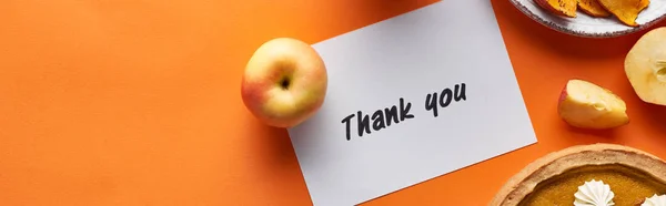 Draufsicht auf Kürbiskuchen, reife Äpfel und Dankeskarte auf orangefarbenem Hintergrund, Panoramaaufnahme — Stockfoto