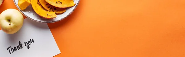 Top view of pumpkin, ripe apples and thank you card on orange background with copy space, panoramic shot — Stock Photo