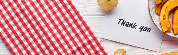 Vista superior de la calabaza, manzanas maduras y gracias tarjeta en la mesa blanca de madera con servilleta a cuadros, tiro panorámico - foto de stock