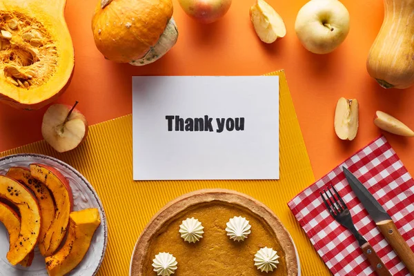 Ansicht von Kürbiskuchen, reifen Äpfeln und Dankeskarte auf orangefarbenem Hintergrund — Stockfoto