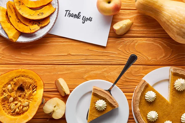 Vista dall'alto di torta di zucca, mele mature e biglietto di ringraziamento su tavolo di legno — Foto stock