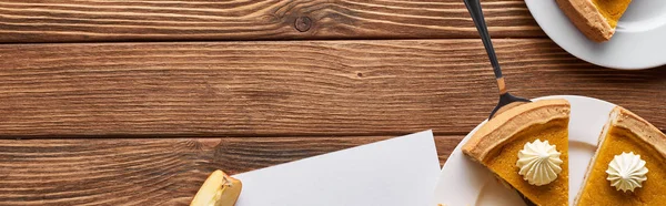 Top view of pumpkin pie on wooden brown table, panoramic shot — Stock Photo