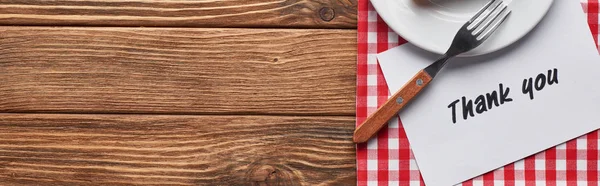 Top view of plate with fork and thank you card on wooden brown table with red plaid napkin, panoramic shot — Stock Photo