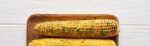Вид зверху на кукурудзу на грилі, що подається за білим дерев'яним столом для вечері вдячності, панорамний знімок — стокове фото