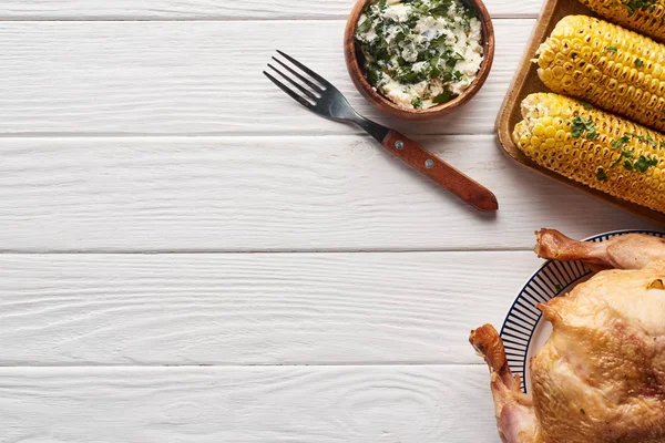 Vue du dessus de la dinde et du maïs servis à table blanche en bois pour le dîner de Thanksgiving — Photo de stock