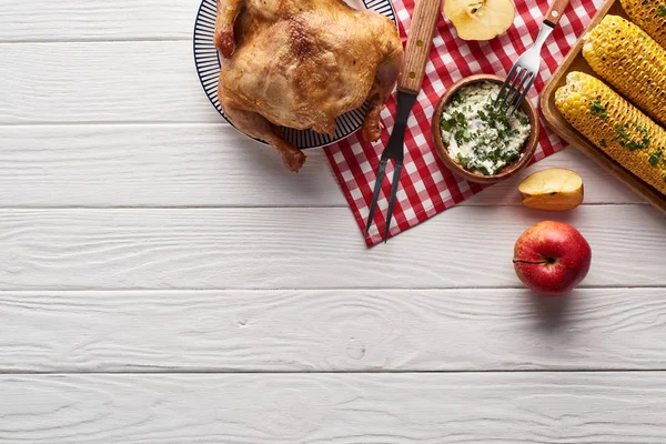 Vista superior de pavo y verduras servidas en mesa de madera blanca con servilleta a cuadros para la cena de Acción de Gracias - foto de stock