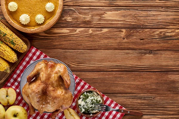 Blick von oben auf Kürbiskuchen, Truthahn und Gemüse, serviert am Holztisch zum Erntedank-Dinner — Stockfoto