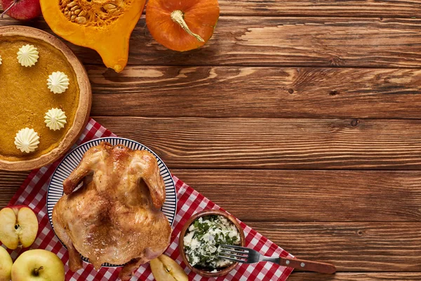 Blick von oben auf Kürbiskuchen, Truthahn und Gemüse, serviert am Holztisch zum Erntedank-Dinner — Stockfoto