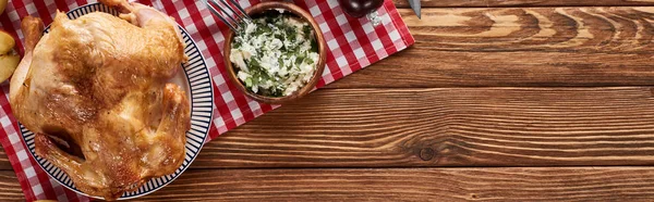 Top view of roasted turkey served on red plaid napkin on wooden table for Thanksgiving dinner, panoramic shot — Stock Photo