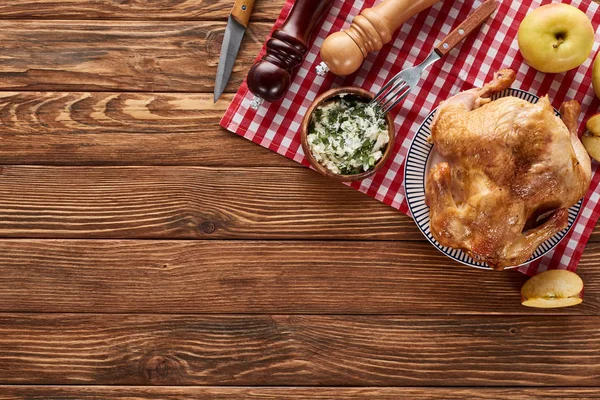 Top view of roasted turkey and apples served on napkin at wooden table for Thanksgiving dinner — Stock Photo