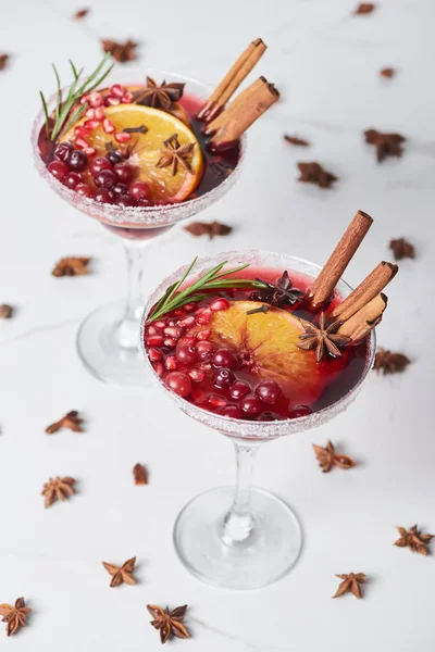 Christmas cocktails with orange, pomegranate and cinnamon on marble table — Stock Photo