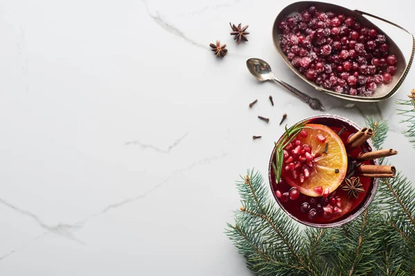 Top view of christmas cocktail with orange, pomegranate, cinnamon and frozen cranberry — Stock Photo