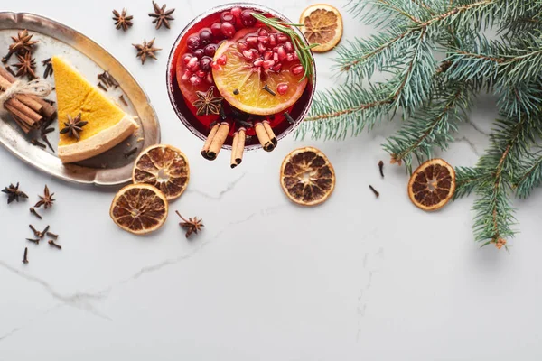 Vista dall'alto del cocktail natalizio con arancia, melograno, cannella e torta su vassoio — Foto stock