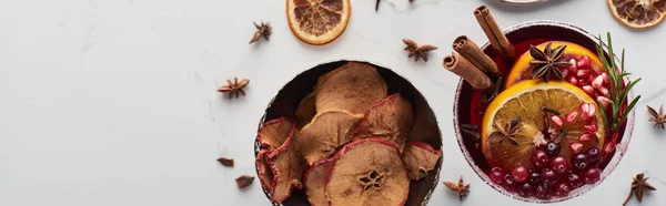 Panoramic shot of christmas cocktail with orange, pomegranate, cinnamon and dry apples — Stock Photo