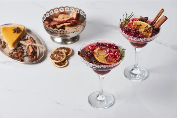 Christmas cocktails with orange, pomegranate, cinnamon, apple pie and dry apples — Stock Photo