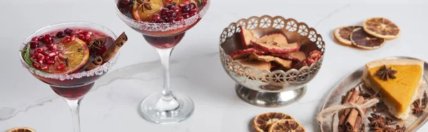 Panoramic shot of christmas cocktails with orange, pomegranate, cinnamon, apple pie and dry apples — Stock Photo