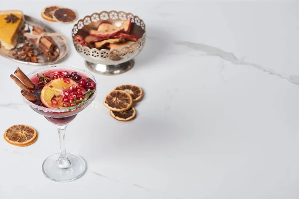 Selective focus christmas cocktail with orange, pomegranate, cinnamon, apple pie and dry apples — Stock Photo