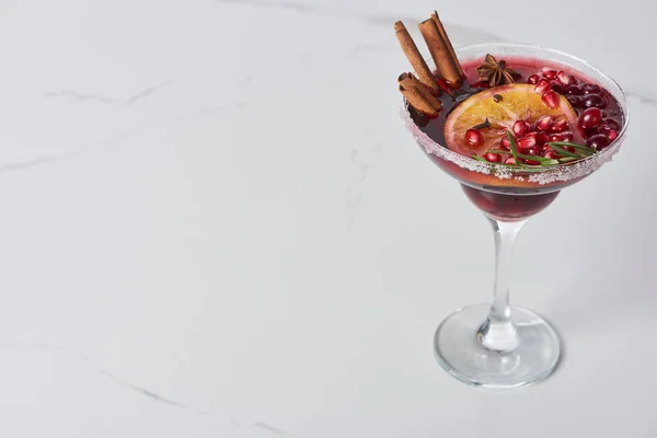 Weihnachtscocktail mit Orange, Granatapfel, Zimt auf Marmortisch — Stockfoto