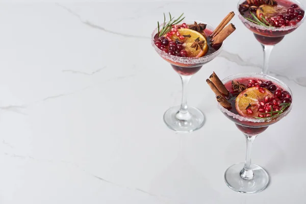 Christmas cocktails with orange, pomegranate, cinnamon on marble table — Stock Photo