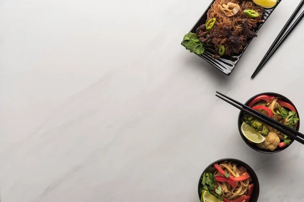 Top view of delicious spicy thai noodles with chopsticks on marble grey surface — Stock Photo