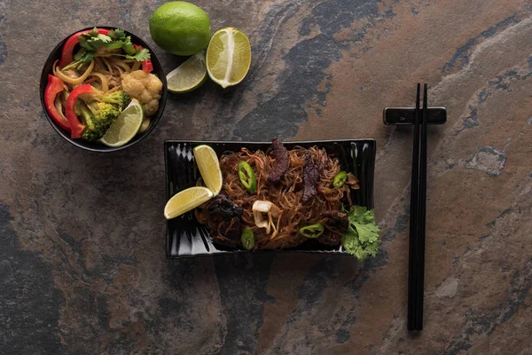 Top view of tasty spicy thai noodles with chopsticks on stone surface — Stock Photo