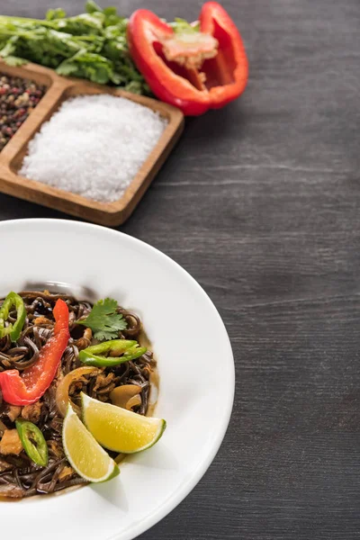 Deliciosos macarrão tailandês picante perto de tempero na superfície cinza de madeira — Fotografia de Stock