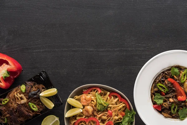 Vista dall'alto di deliziosi spaghetti tailandesi piccanti sulla superficie grigia in legno — Foto stock