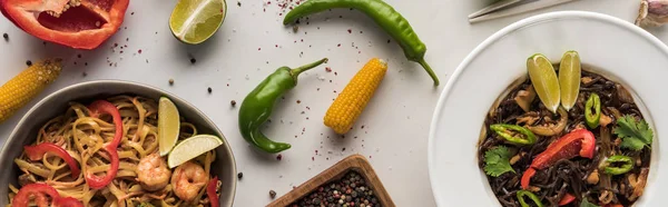 Vista superior de deliciosos fideos tailandeses picantes en la superficie gris mármol, plano panorámico - foto de stock