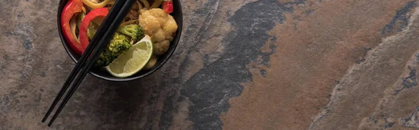 Top view of thai noodles in bowl with chopsticks on stone surface, panoramic shot — Stock Photo