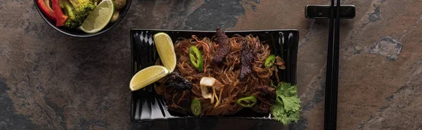 Top view of thai noodles with beef near chopsticks, panoramic shot — Stock Photo