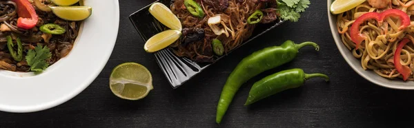 Vista dall'alto delle tagliatelle tailandesi vicino agli ingredienti sulla superficie grigio legno, colpo panoramico — Foto stock