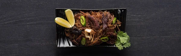 Vue du dessus des nouilles thaï à la viande sur une surface grise en bois, vue panoramique — Photo de stock