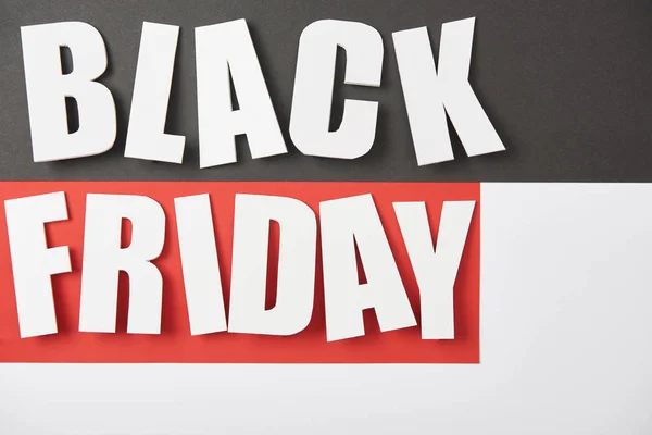 Top view of black friday lettering on black, white and red background — Stock Photo