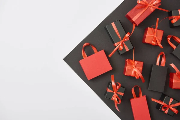 Draufsicht auf dekorative Geschenkboxen und Einkaufstaschen auf weißem, schwarzem Hintergrund mit Kopierraum — Stockfoto