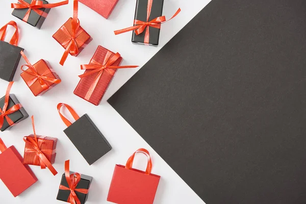 Vista superior de cajas de regalo decorativas y bolsas de compras en blanco, fondo negro con espacio de copia - foto de stock
