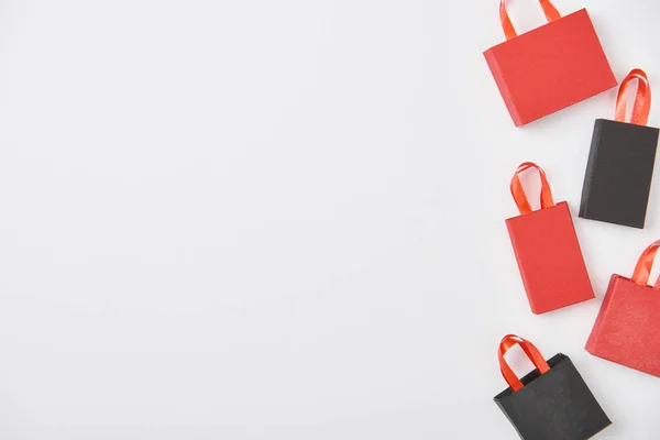 Vista superior de bolsas de compras negras y rojas sobre fondo blanco - foto de stock