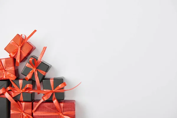 Vista superior de los regalos en negro y rojo sobre fondo blanco - foto de stock