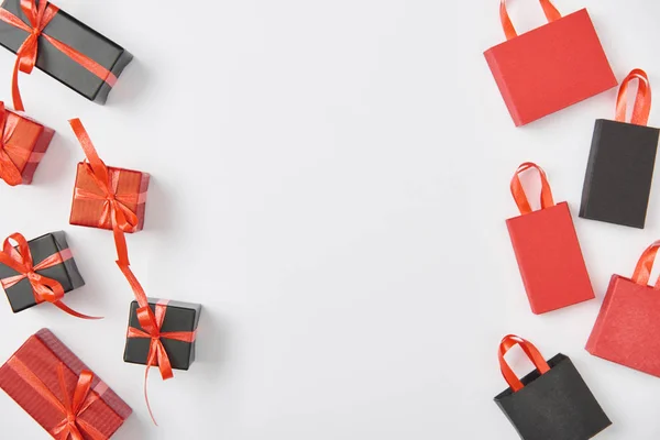 Top view of black and red presents and shopping bags on white background — Stock Photo