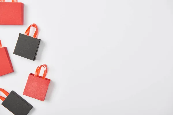 Vista dall'alto di nero e rosso decorativo shopping bags su sfondo bianco — Foto stock