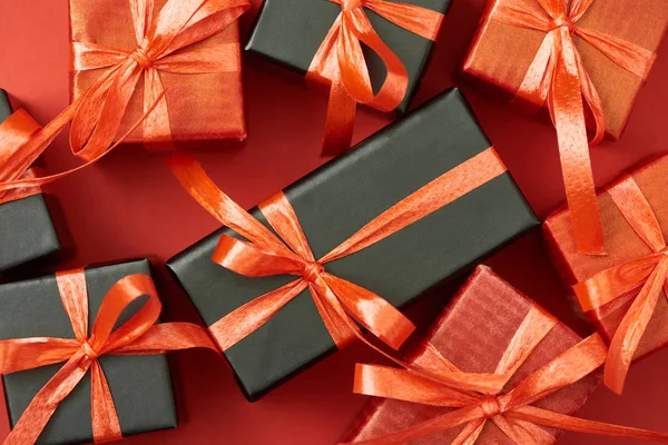 Top view of gift boxes with bows and ribbons on red background — Stock Photo