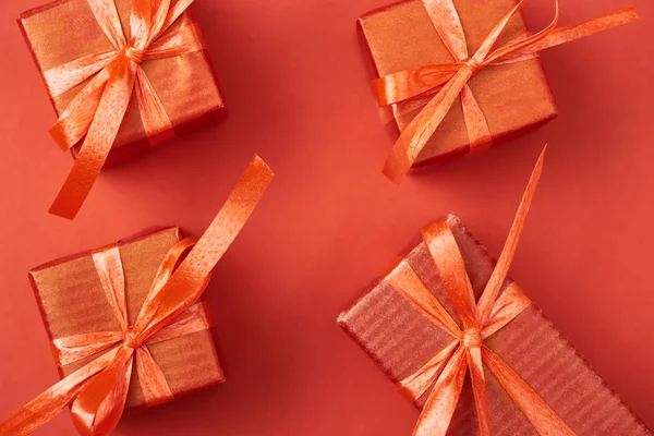 Top view of gift boxes with bows and ribbons on red background — Stock Photo