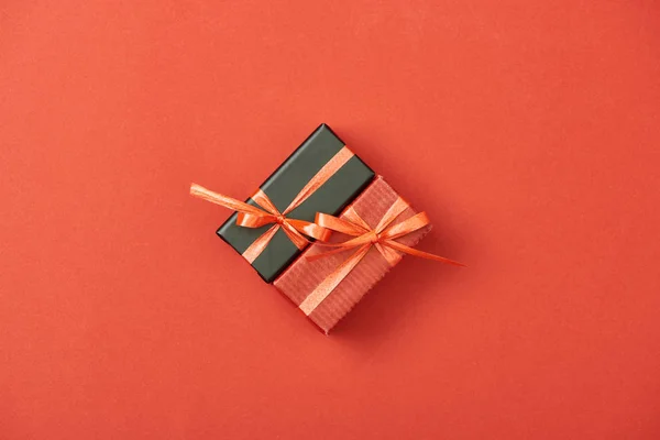 Pose plate avec des boîtes-cadeaux et des sacs à provisions sur fond rouge — Photo de stock