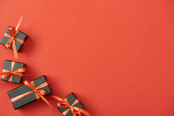 Draufsicht auf kleine schwarze Geschenkboxen auf rotem Hintergrund mit Kopierraum — Stockfoto