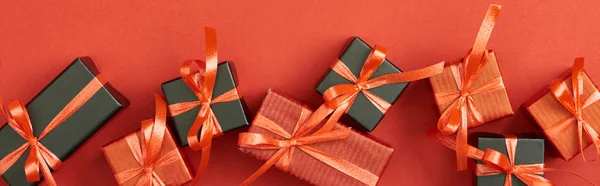 Top view of small gift boxes on red background, panoramic shot — Stock Photo