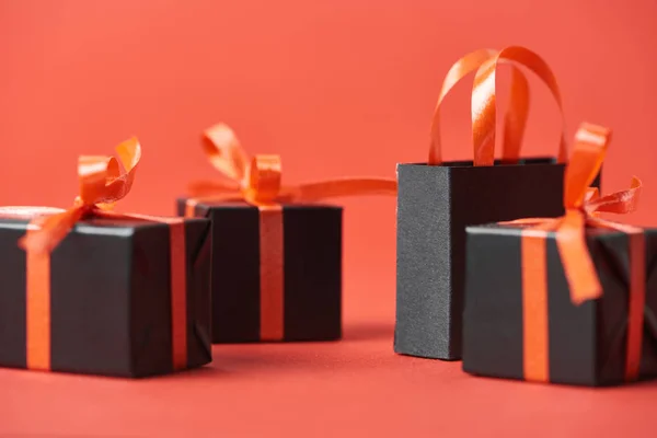 Close up view of black friday presents and shopping bag on red background — Stock Photo