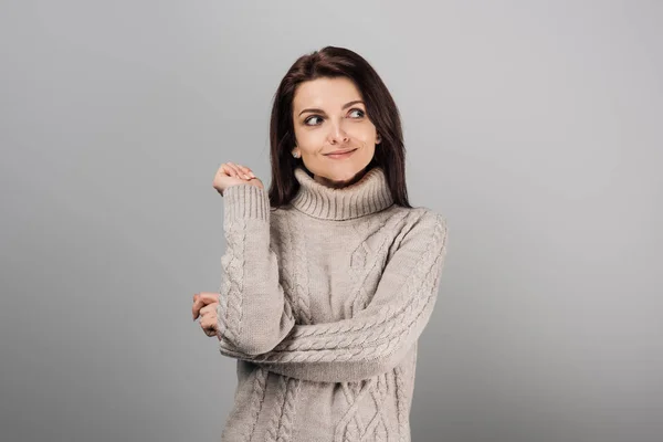 Cheerful woman in sweater looking away isolated on grey — Stock Photo